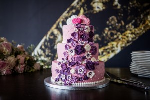 Bruidstaarten - roze bruidstaart met waterval aan paarse en witte bloemen