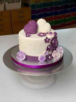 Bruidstaarten - Witte bruidstaart met paarse bloemen en 3D harten