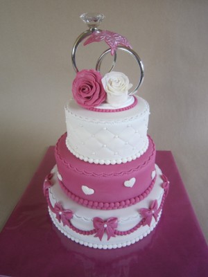 Bruidstaarten - Roze en witte bruidstaart met ringen als taarttopper